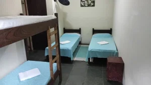 Cama em suíte compartilhada com duas pessoas